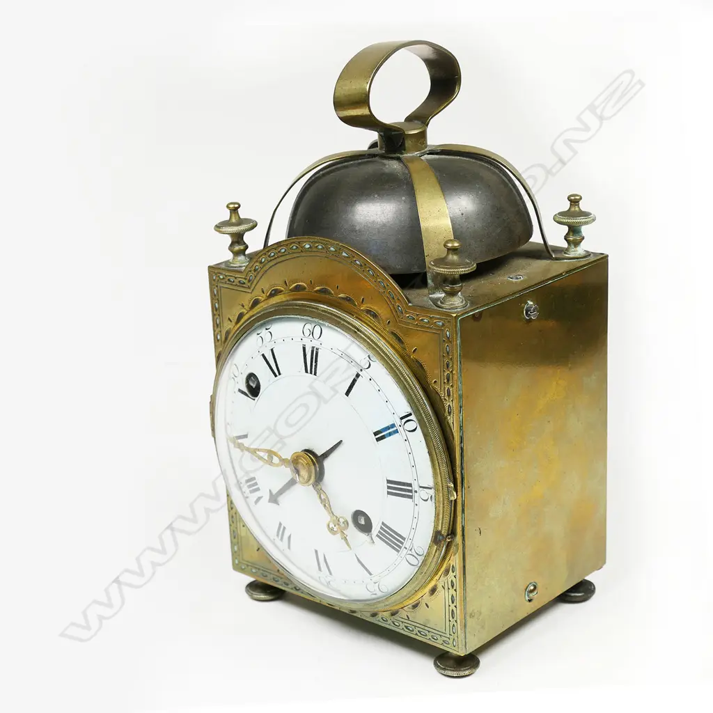 A 19thC brass cased alarm striking lantern clock - the over-head bell supported by four brass cross-over straps secured by the corner finials, convex white enamel dial with Roman numerals. Running, alarm requiring attention. H.150mm. Image 1++