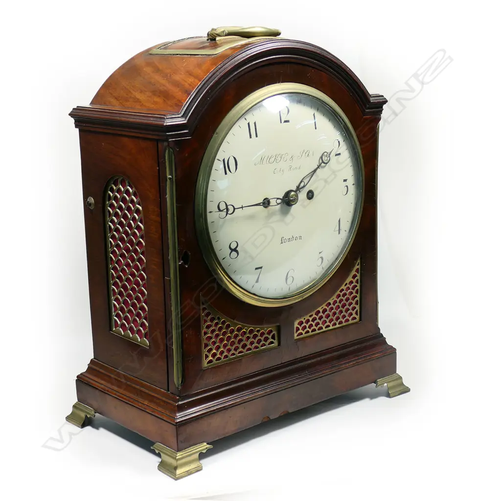 A late 18th century mahogany bracket clock by George Mackie & Son, City Road, London - with 8-day twin-fusee, engraved movement, striking the hours on a bell, pendulum lock screw absent, with winding and door keys. The case of break arch form with carry handle, with circular convex repainted dial, with Arabic numerals, original brass scale fretwork to lower quarters and the sides, arched glazed door to rear, standing on brass ogee bracket feet. H.395mm, Image 1++