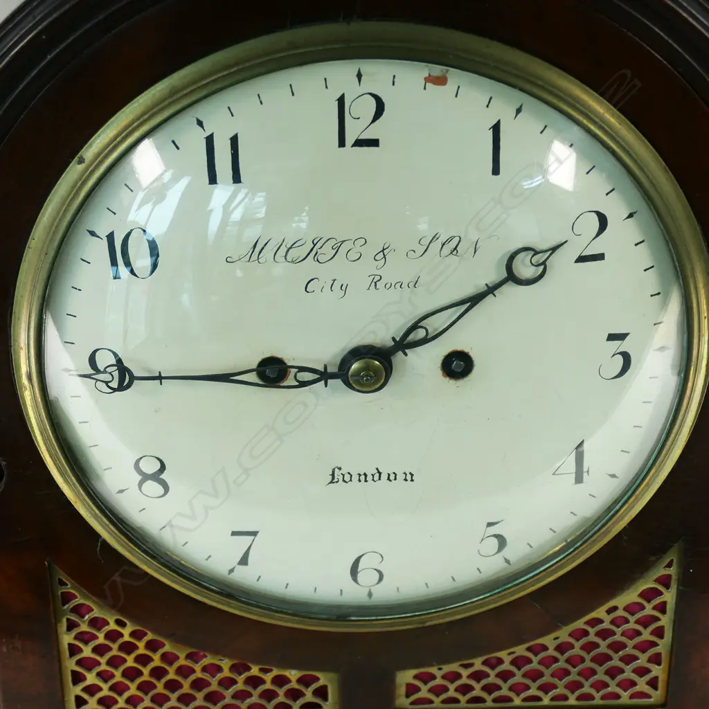 A late 18th century mahogany bracket clock by George Mackie & Son, City Road, London - with 8-day twin-fusee, engraved movement, striking the hours on a bell, pendulum lock screw absent, with winding and door keys. The case of break arch form with carry handle, with circular convex repainted dial, with Arabic numerals, original brass scale fretwork to lower quarters and the sides, arched glazed door to rear, standing on brass ogee bracket feet. H.395mm, Image 1++