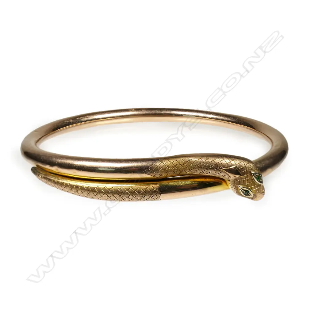 An early 20thC 9ct rose gold snake 'slave' bangle - the snake's head with emerald set eyes. Dia.86mm. 14.38gms. Image 1++