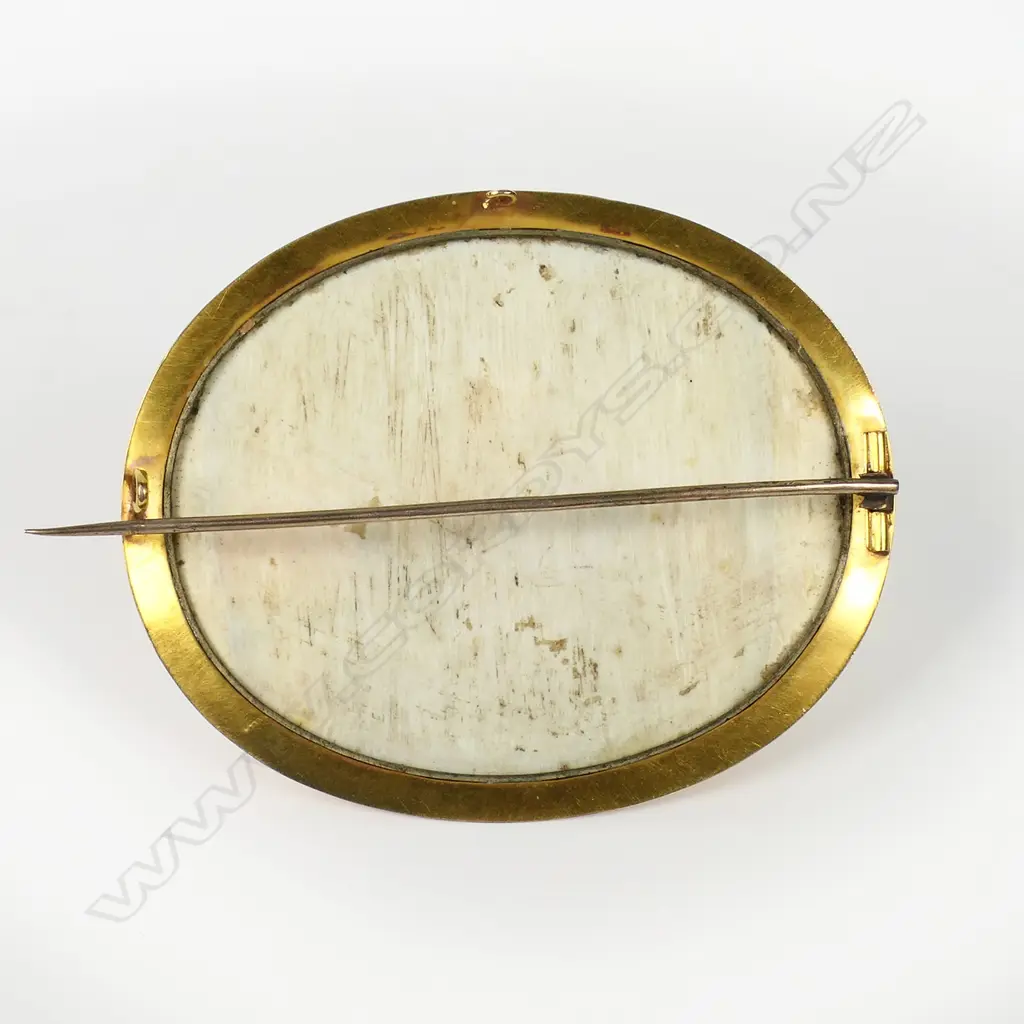 A 19thC gold framed large Grand Tour Taj Mahal painted ivory brooch - the glazed oval ivory panel with a finely detailed image reflecting in the foreground water. In gilded 14ct gold tested frame. W.70mm. In leather case 15.3gms. Image 1++