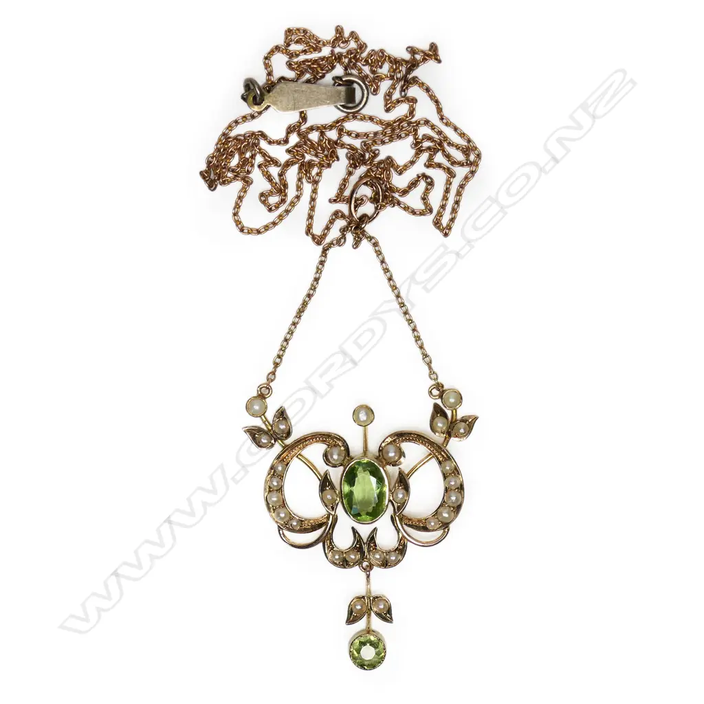 A 9ct gold Edwardian pendant - the floral and leaf frame set with seed pearls , a peridot to the centre with a smaller peridot suspended from base. With very fine 9ct rose gold chain (metal hook and eye clasp). 4.8gms. Image 1++