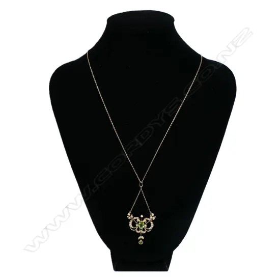 A 9ct gold Edwardian pendant - the floral and leaf frame set with seed pearls , a peridot to the centre with a smaller peridot suspended from base. With very fine 9ct rose gold chain (metal hook and eye clasp). 4.8gms.