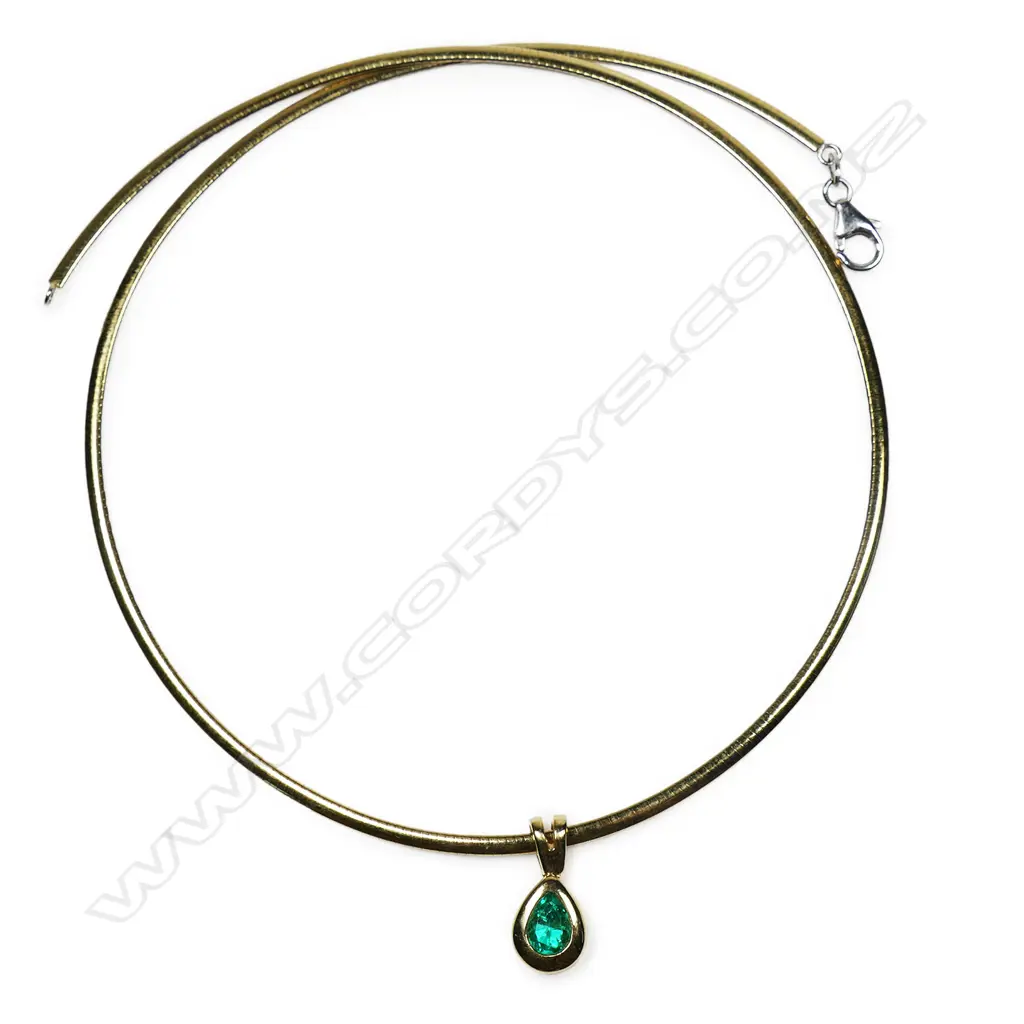 An 18ct gold necklace and emerald pendant - the flat snake link collar yellow one side, white the other. A facet pear cut emerald in a rub over mount pendant. 16grams total Image 1++