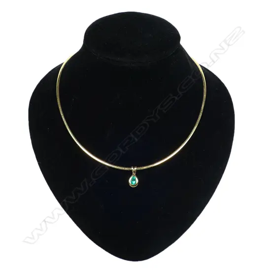 An 18ct gold necklace and emerald pendant - the flat snake link collar yellow one side, white the other. A facet pear cut emerald in a rub over mount pendant. 16grams total