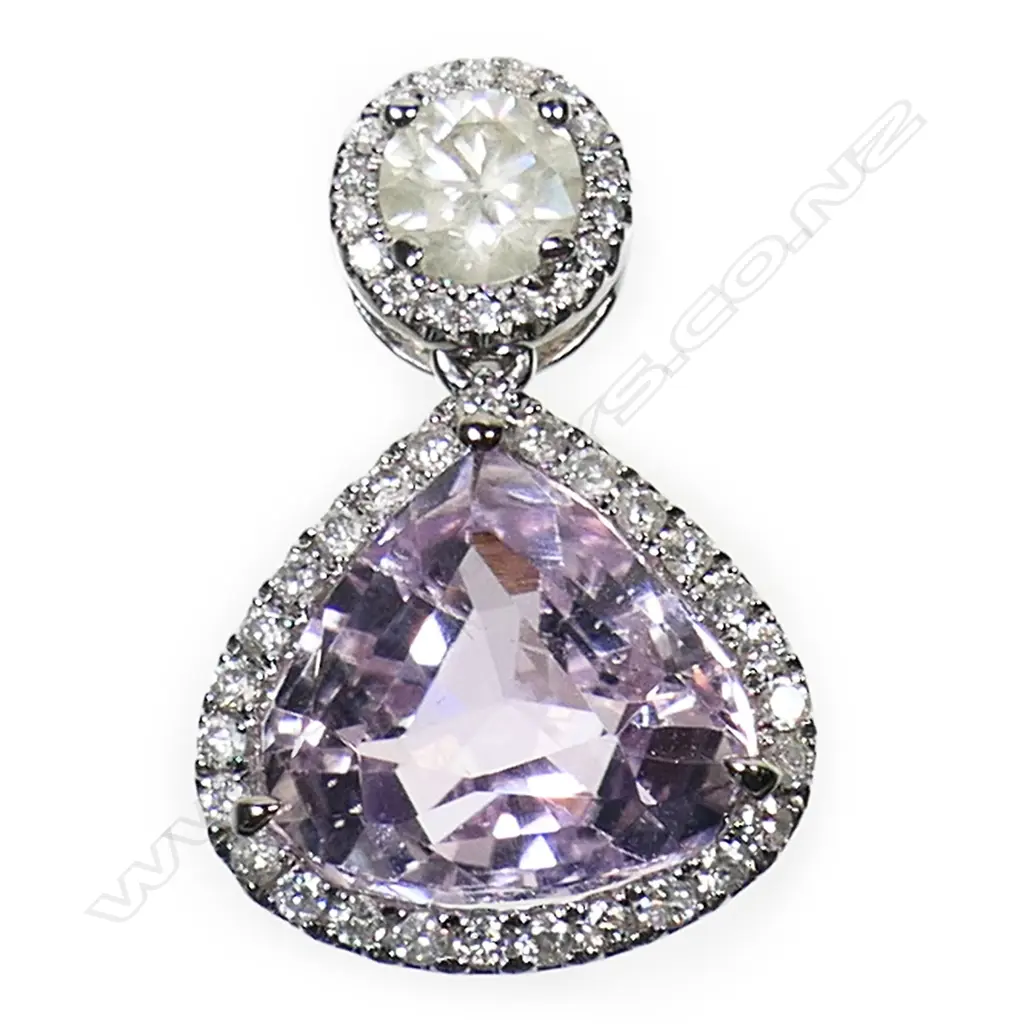 A 14ct white gold kunzite and diamond halo drop pendant - a 4.43ct trillion cut light pink-purple kunzite (minor eye visible inclusions), claw set, surmounted by a 0.36ct round brilliant cut diamond. Embellishing the design in individual halos are forty-five round brilliant cut diamonds (Colour J-K, Clarity SI-SI2), micro claw set. TDW. 0.60ct. Image 1++