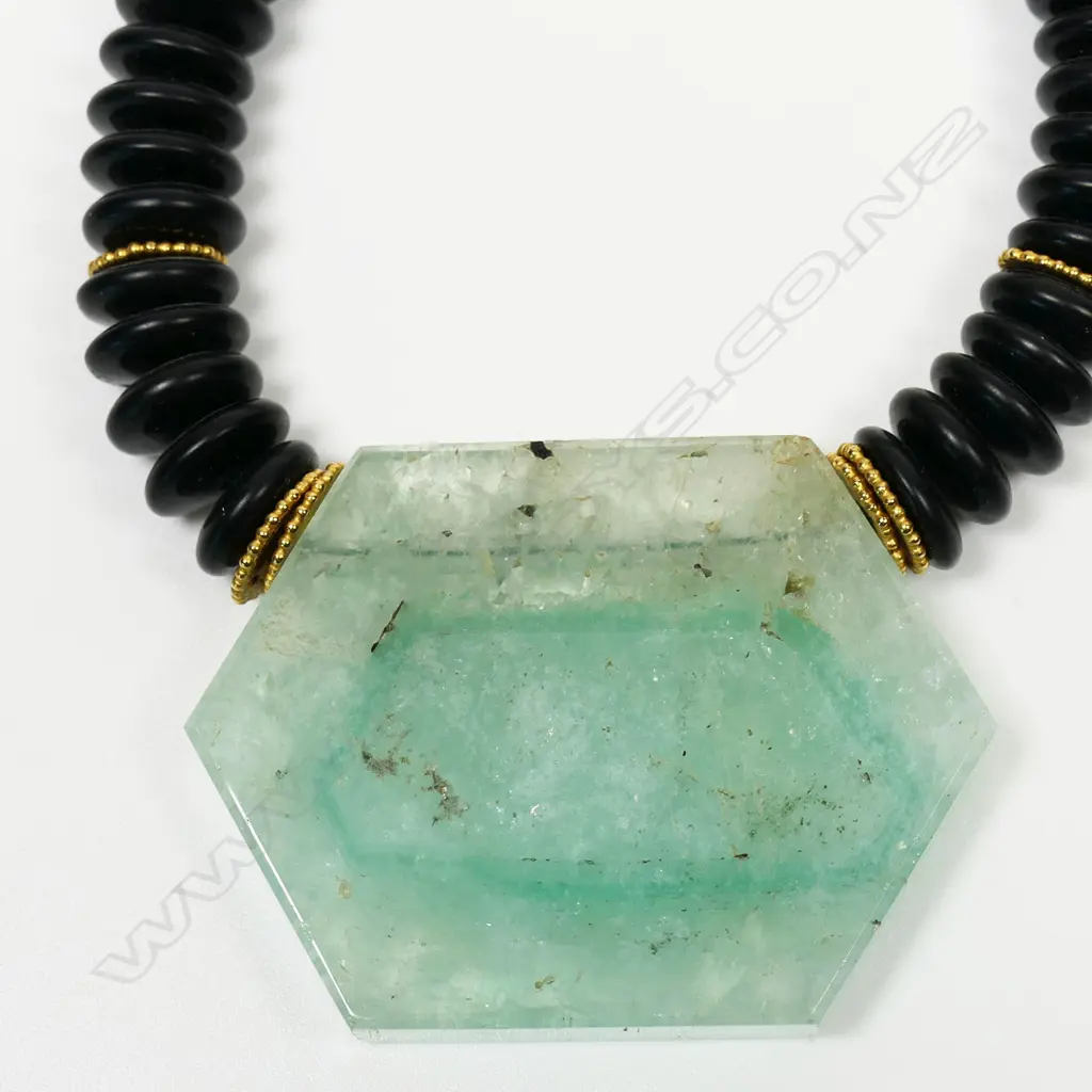 A designer onyx and quartz pendant necklace with 18ct yellow gold fittings - the onyx discs with 14 gold discs highlighting, the pendant as a hexagonal green and clear semi translucent panel. 18ct yellow gold clasp. Valuation available. Image 1++