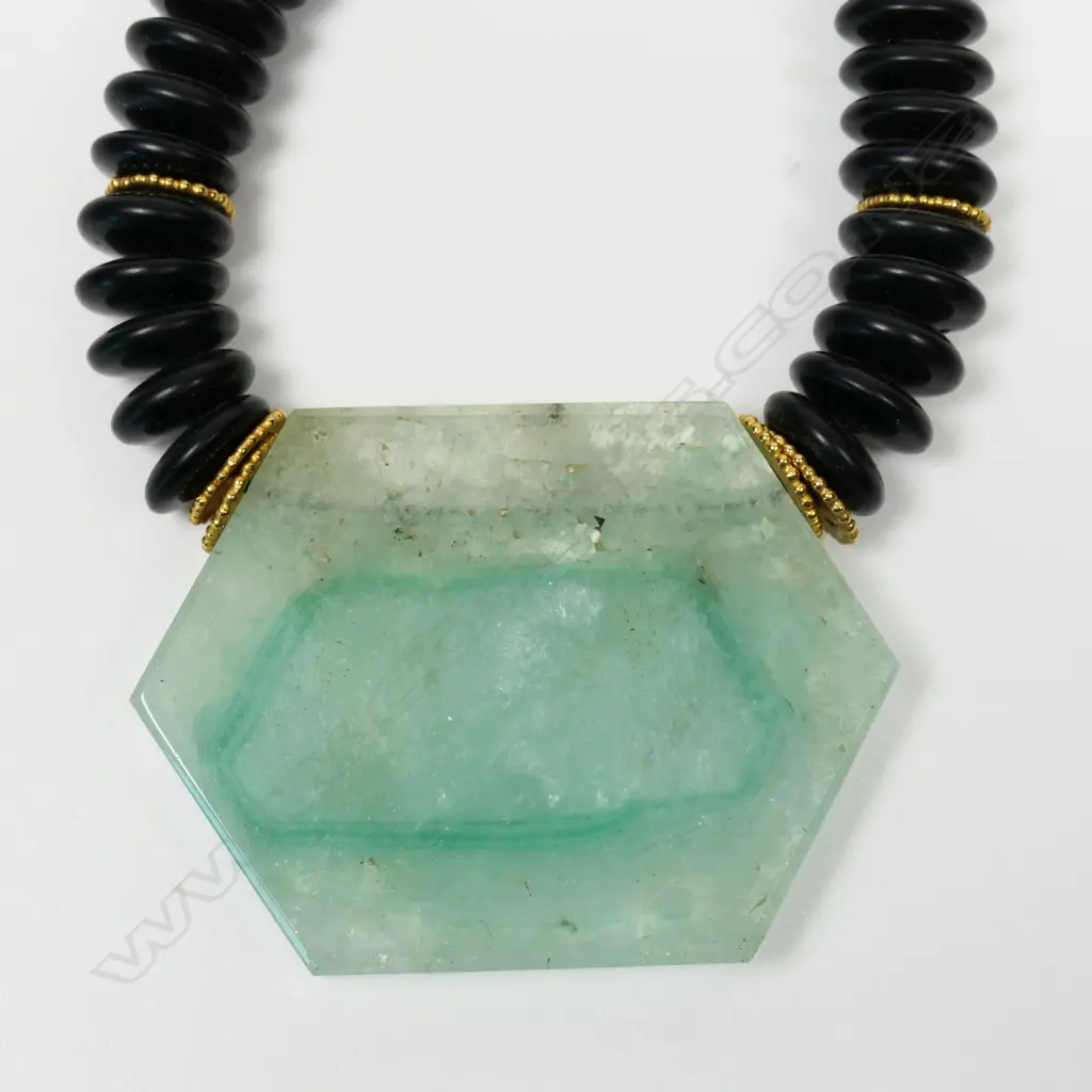 A designer onyx and quartz pendant necklace with 18ct yellow gold fittings - the onyx discs with 14 gold discs highlighting, the pendant as a hexagonal green and clear semi translucent panel. 18ct yellow gold clasp. Valuation available. Image 1++