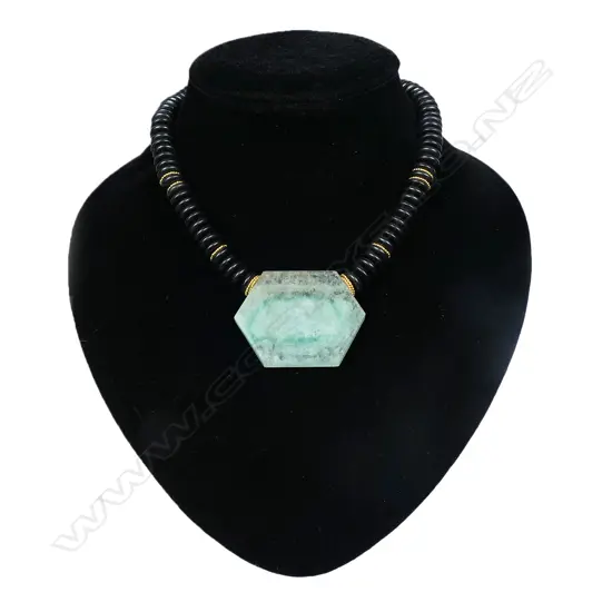 A designer onyx and quartz pendant necklace with 18ct yellow gold fittings - the onyx discs with 14 gold discs highlighting, the pendant as a hexagonal green and clear semi translucent panel. 18ct yellow gold clasp. Valuation available.