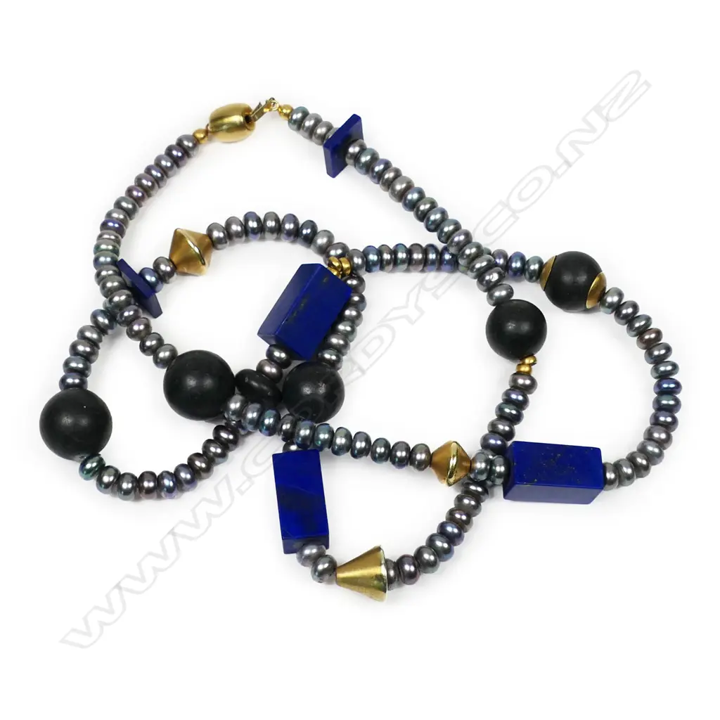 A modern designer fresh water pearl lapis lazuli onyx and gold necklace - the 99 fresh water pearls of grey to purple tone and 6.4 to 6.9mm diameter highlighted with six round onyx beads, five lapis beads and various gold plated beads, with 14ct yellow gold clasp. L.730mm. Valuation available. Image 1++