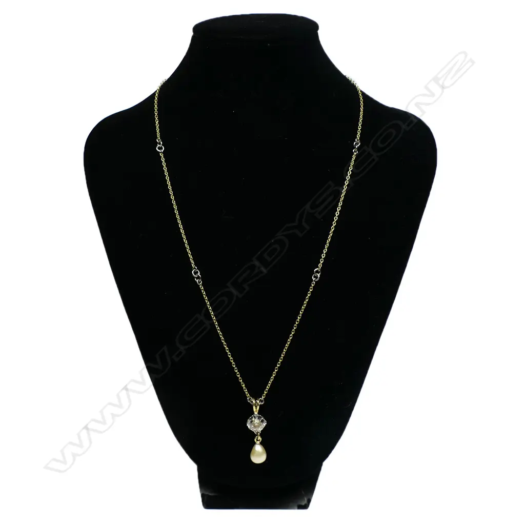 A solitaire 3ct+ old cut diamond set in an 18ct yellow gold necklace - the diamond of champagne tone with chipping to its edge, secured by four double claws with a large oval form cultured pearl below. The chain with repeating highlights of white gold links. 10.95gms. Chain L.500mm. Image 1++