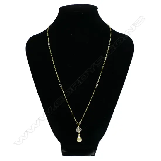 A solitaire 3ct+ old cut diamond set in an 18ct yellow gold necklace - the diamond of champagne tone with chipping to its edge, secured by four double claws with a large oval form cultured pearl below. The chain with repeating highlights of white gold links. 10.95gms. Chain L.500mm.