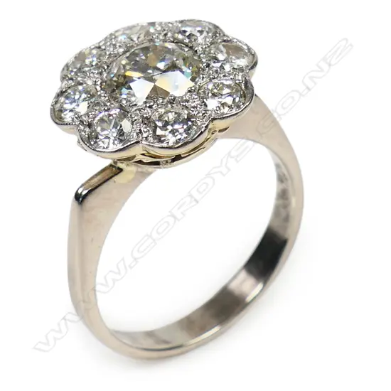 An impressive old 18ct gold and large diamond cluster ring - the central brilliant cut diamond of approx. 1.25ct. Bead set and framed by eight smaller brilliant cut diamonds to a white gold topped yellow gold under basket mount. On an 18ct white gold later shank. Ring size P.