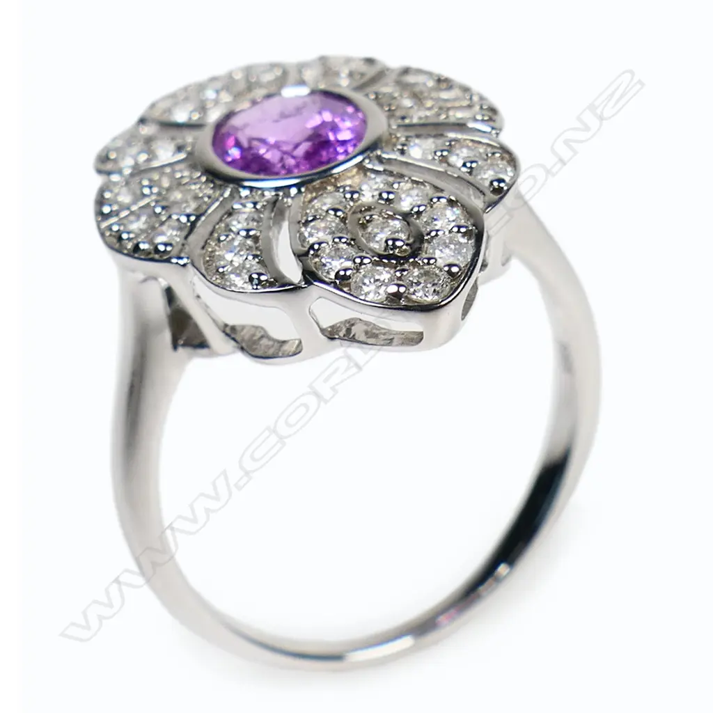 A 14ct white gold pink sapphire and diamond antique style ring - a 0.98ct oval cut pink sapphire(moderate natural inclusions), bezel set and embellished with forty-four round brilliant cut diamonds (Colour H-J, Clarity SI-I1) bead set. TDW. 0.45ct. Ring size K. Image 1++
