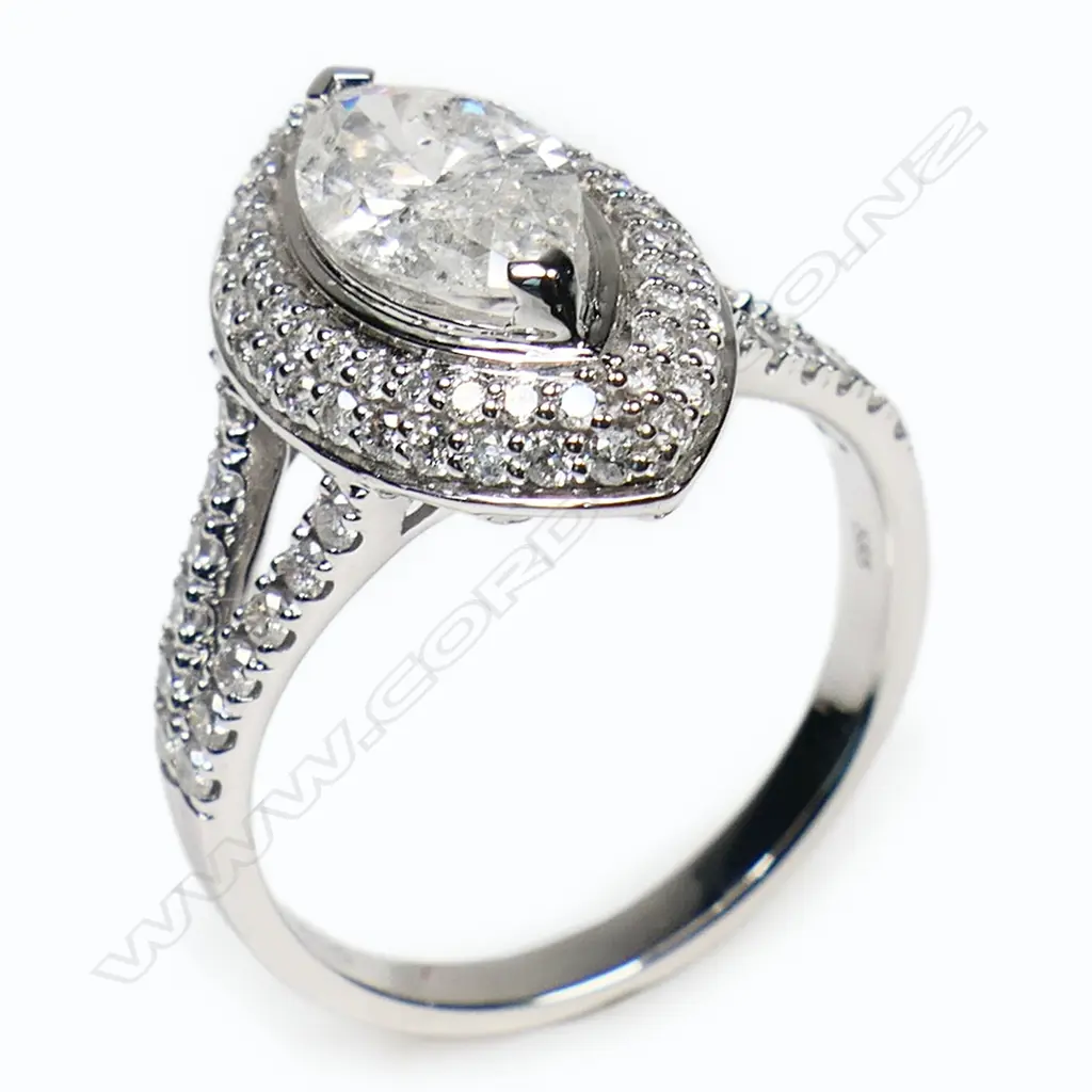 A 14ct white gold diamond double halo ring - a 1.06ct marquise cut diamond (Colour G-H, Clarity SI1-SI2), claw set and surrounded by a double halo of round brilliant cut diamonds with further diamonds set to the split shoulders (Colour H-H, Clarity SI1-SI2), micro bead set. TDW. 1.72ct. Ring size M. Image 1++