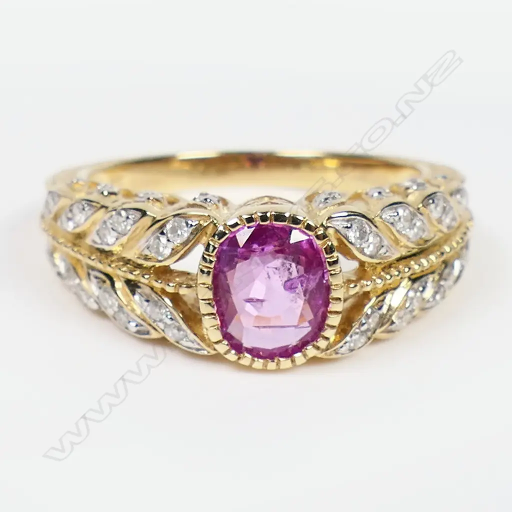 A 14ct gold pink sapphire and diamond dress ring - a 1.03ct oval facet cut deep purplish-pink sapphire (minor eye visible inclusions), bezel set, decorating the leaf inspired band and mount are forty round brilliant cut diamonds (Colour J-K, Clarity SI2-I2), micro claw set. TDW. 0.21ct. Ring size L. Image 1++
