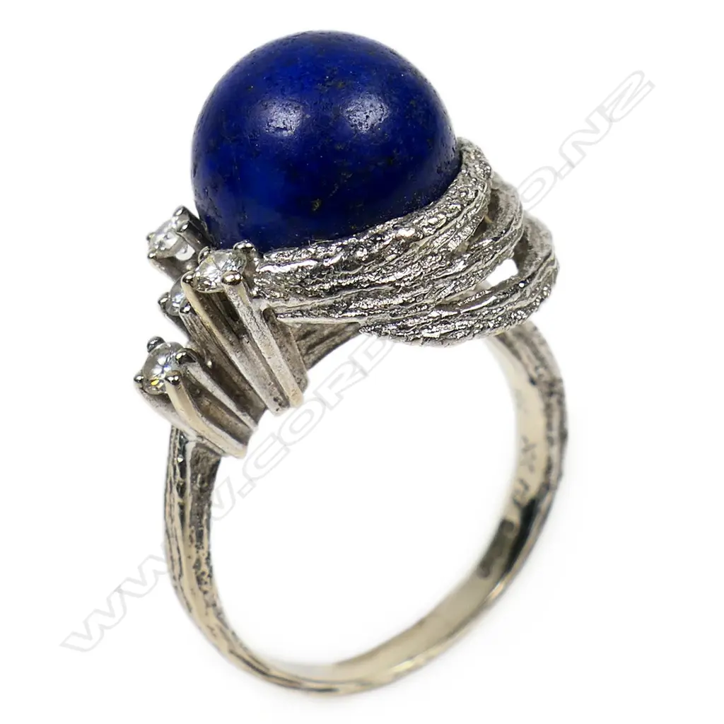 A 14ct white gold lapis lazuli and diamond set designer ring - the round cut lapis lazuli of 11mm diameter in a textured multi ring mount highlighted with four round brilliant cut diamonds. 7.1gms. Valuation available. Image 1++