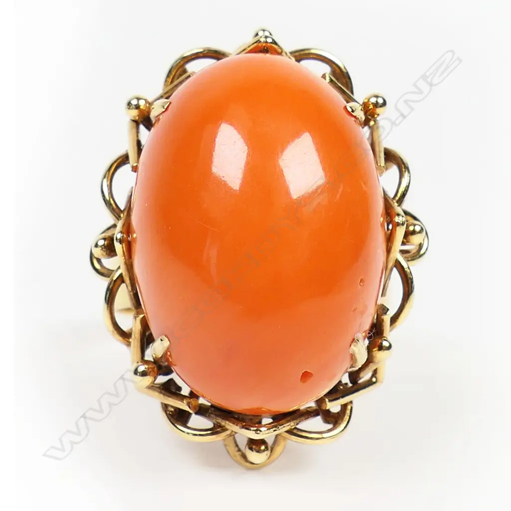 A vintage 14ct yellow gold and coral ring - the large oval orange / red coral cabochon claw set in collet with ornate wire undersetting. 11gms. Valuation available. Image 1++