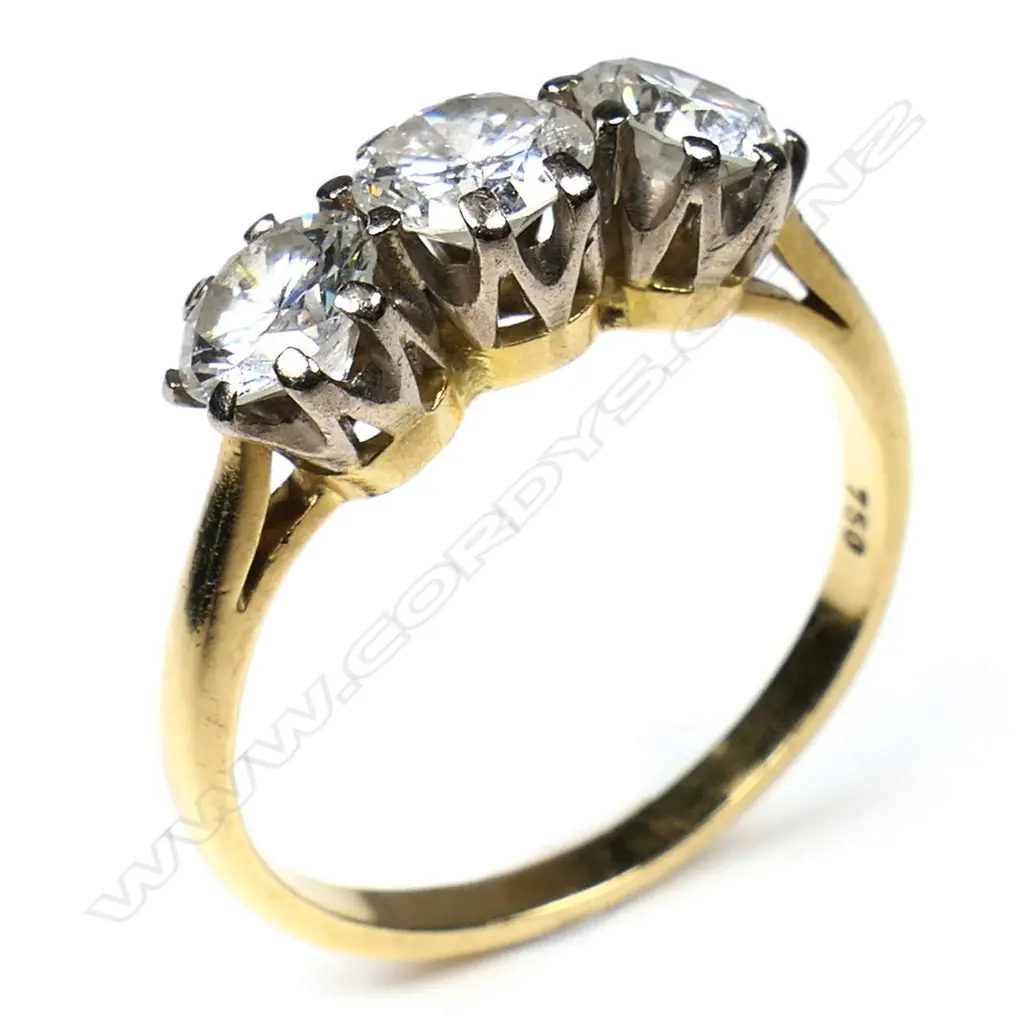 An estate 18ct yellow gold and three stone diamond ring - the brilliant cuts with an approx. 0.80ct centre stone flanked by approx. 0.50ct each. Some inclusions, some claws requiring attention. 3.85gms. Image 1++