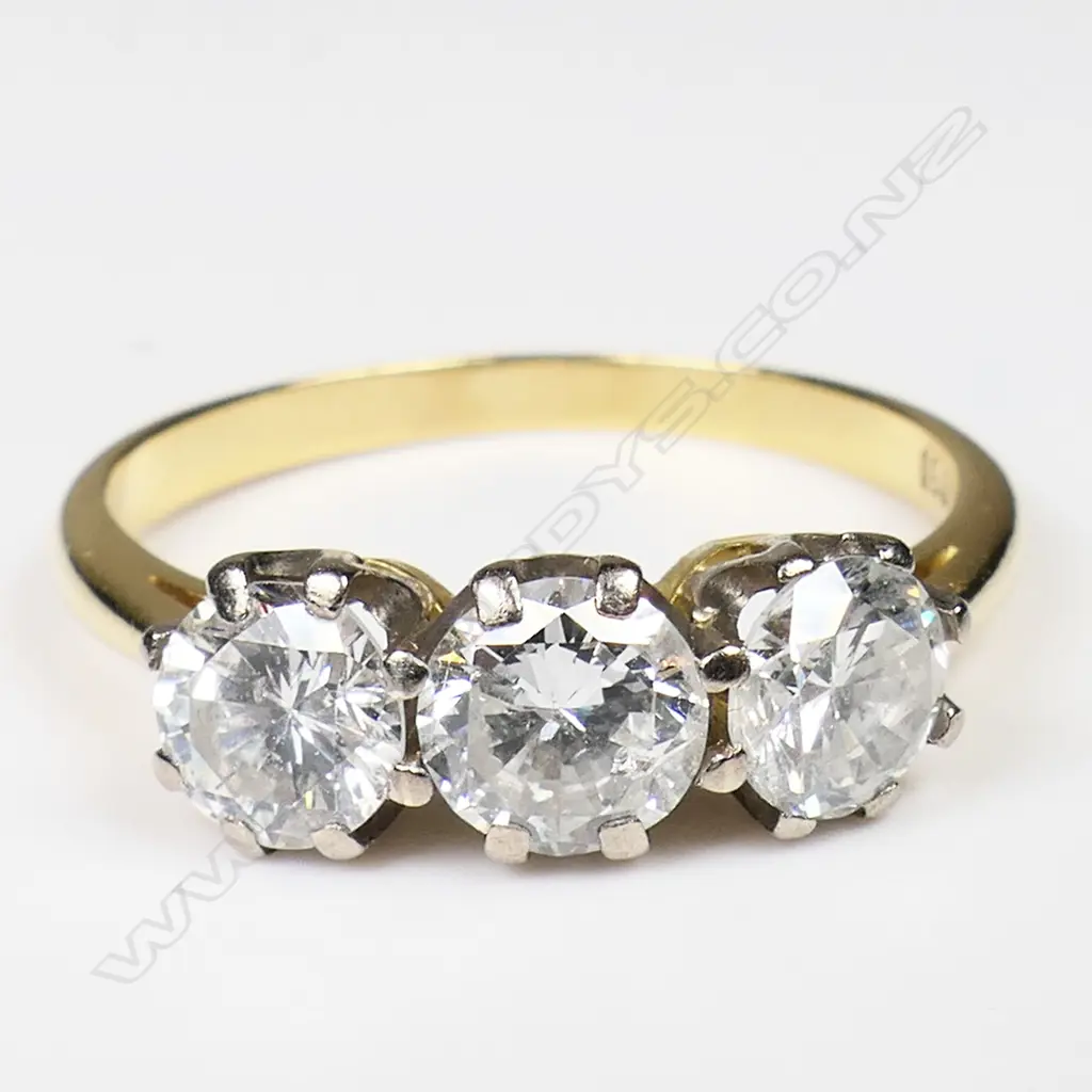 An estate 18ct yellow gold and three stone diamond ring - the brilliant cuts with an approx. 0.80ct centre stone flanked by approx. 0.50ct each. Some inclusions, some claws requiring attention. 3.85gms. Image 1++