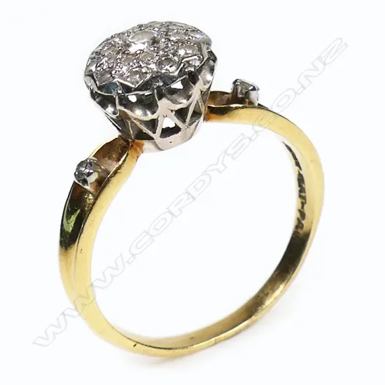 An 18ct yellow gold and platinum diamond cluster ring - twenty-three round brilliant cut and single cut diamonds (Colour I-K, Clarity SI1-P1) set in a cluster, with a single cut diamond to each shoulder. TDW. 0.51ct. Ring size M.