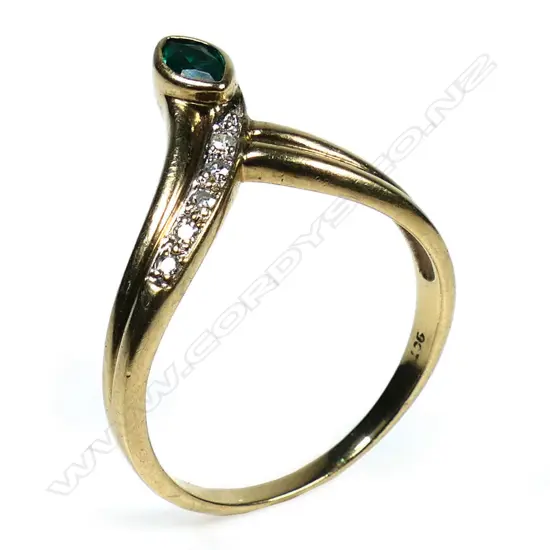 A 9ct gold emerald and diamond dress ring - a 0.30ct marquise cut moderate deep green emerald (lab created with eye clean clarity), bezel set, with five round eight cut diamonds (Colour H-I, Clarity P1), micro bead set, wishbone style. TDW. 0.08ct. Ring size P.