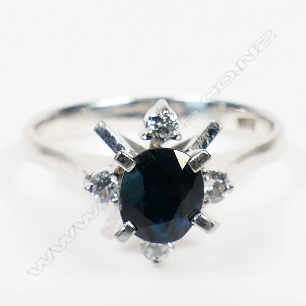 A 14ct white gold sapphire and diamond antique style ring - a 0.98ct oval cut deep royal blue sapphire (slight-moderate inclusions), claw set with four round brilliant cut diamonds (Colour F-G, Clarity VS1) claw set. TDW.0.10ct. Ring size N. Image 1++