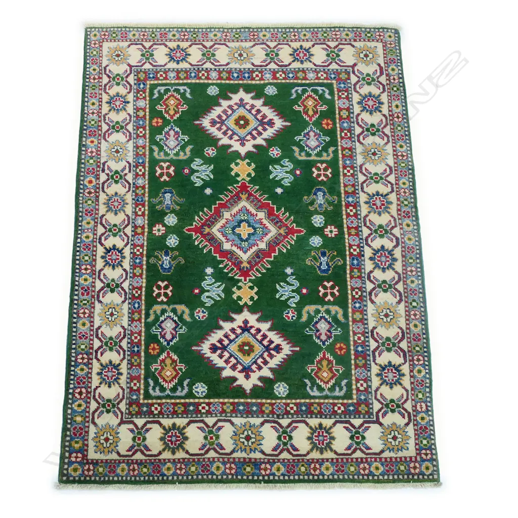 A hand-knotted hand-knotted Kazak rug, the green field decorated with three diamond shaped medallions and various geometric patterns, multiple border guards in a cream and blue ground. 1500 x 1000mm. Image 1++