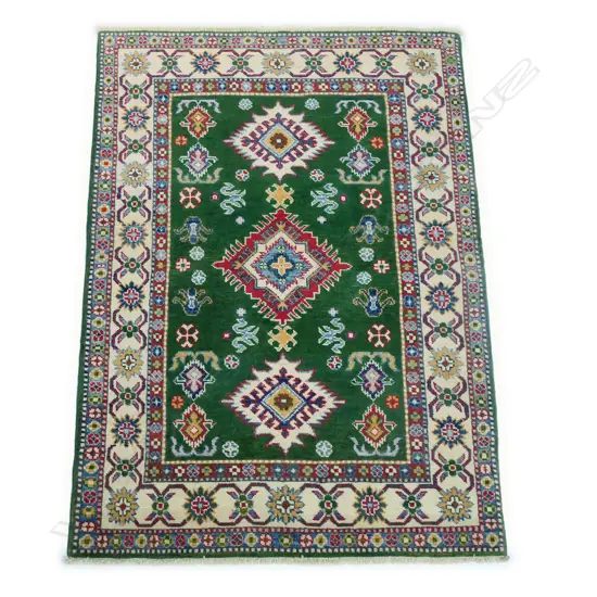 A hand-knotted hand-knotted Kazak rug, the green field decorated with three diamond shaped medallions and various geometric patterns, multiple border guards in a cream and blue ground. 1500 x 1000mm.