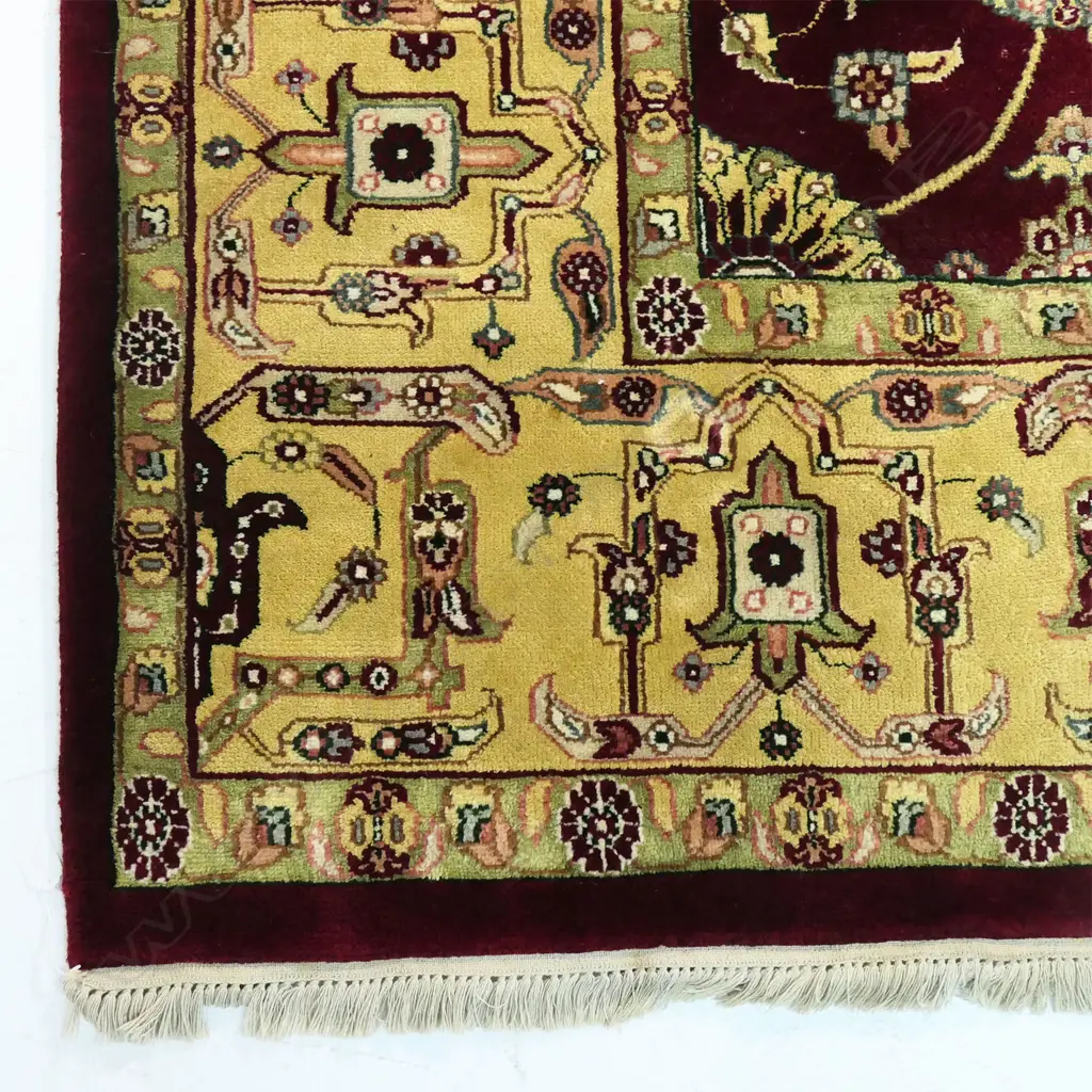 A large Indo-Persian hand-knotted wool on cotton rug, the maroon field decorated with floral medallions surrounded by flowering vines, multiple border guards with geometric shapes. (Retail $7,000 in 2014). 2400 x 3130mm. Image 1++