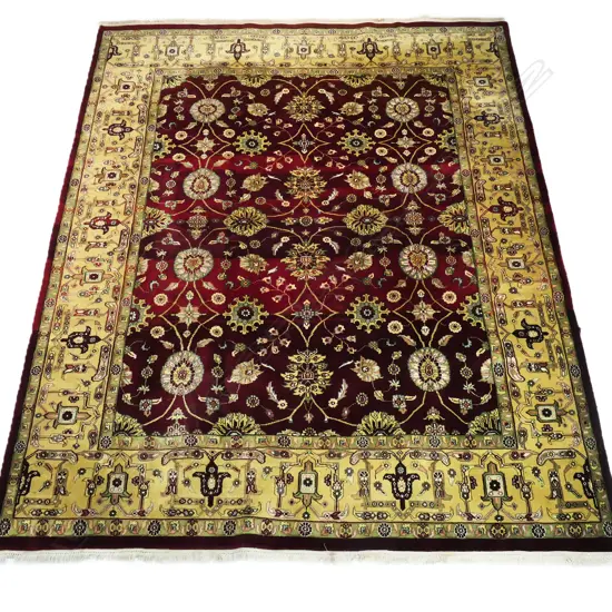 A large Indo-Persian hand-knotted wool on cotton rug, the maroon field decorated with floral medallions surrounded by flowering vines, multiple border guards with geometric shapes. (Retail $7,000 in 2014). 2400 x 3130mm.