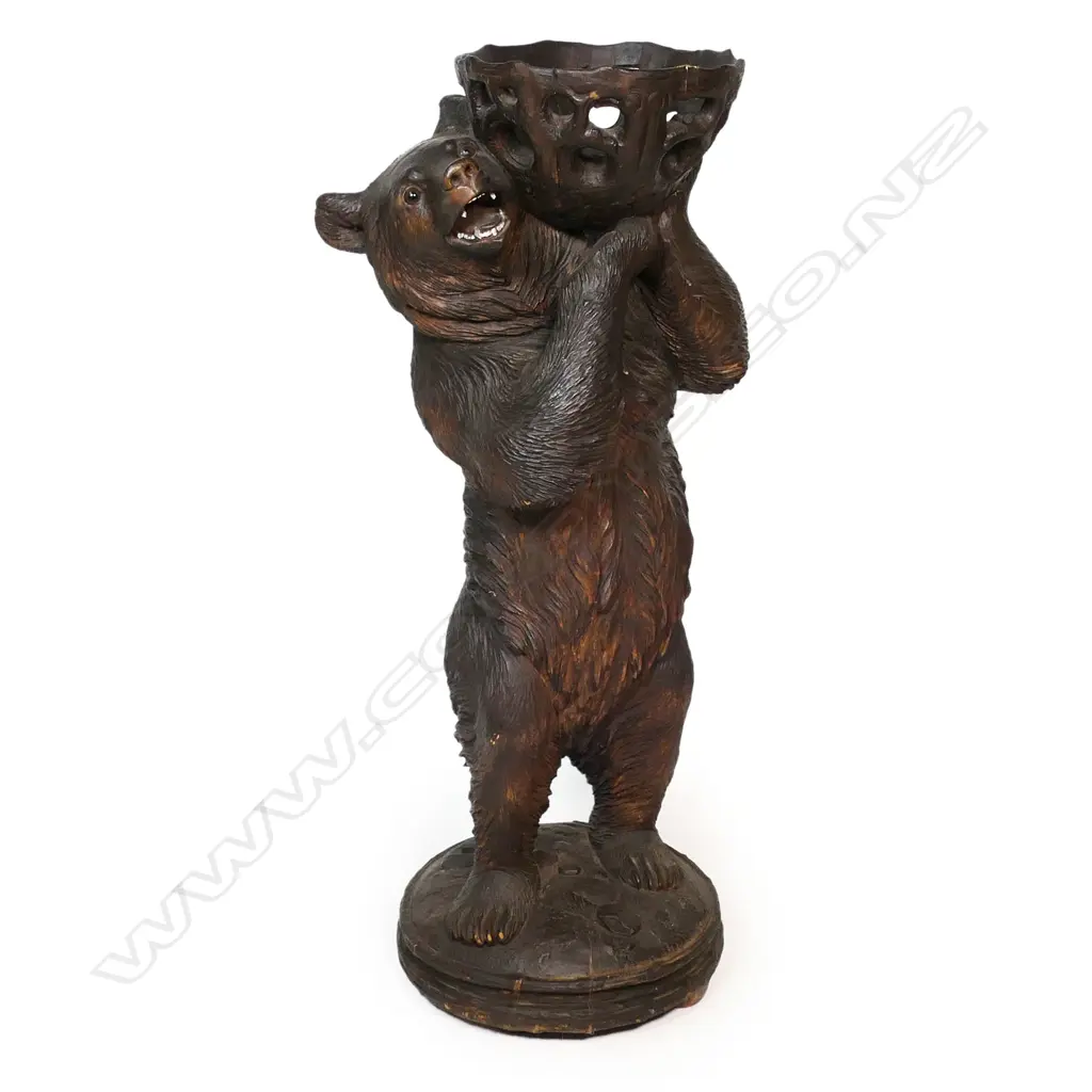 A late 19thC Black Forest carved large floor standing bear with basket - he stands holding aloft a pierced and carved branch form basket. His open mouth with carved and white painted teeth, glass set eyes. On circular domed base with further carved naturalistic detail. H.945mm. Image 1++
