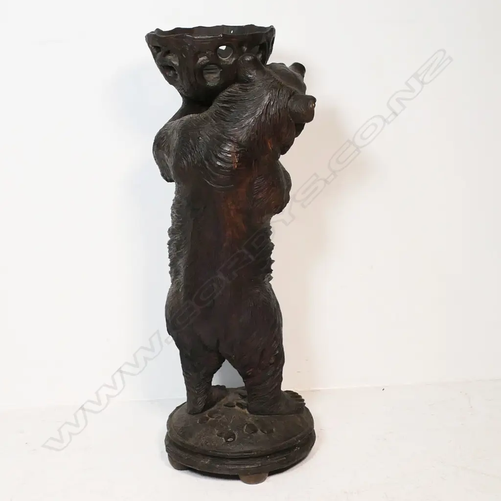 A late 19thC Black Forest carved large floor standing bear with basket - he stands holding aloft a pierced and carved branch form basket. His open mouth with carved and white painted teeth, glass set eyes. On circular domed base with further carved naturalistic detail. H.945mm. Image 1++