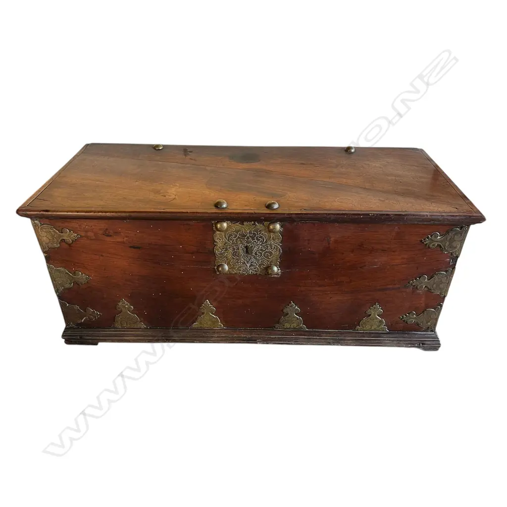 A 19thC mahogany Zanzibar large trunk - flat top, with large brass domed bosses, lock plate, engraved and fret cut brackets and side handles. The top and back with split. 1430 x 600 x 595mm. Good old patina. Image 1++