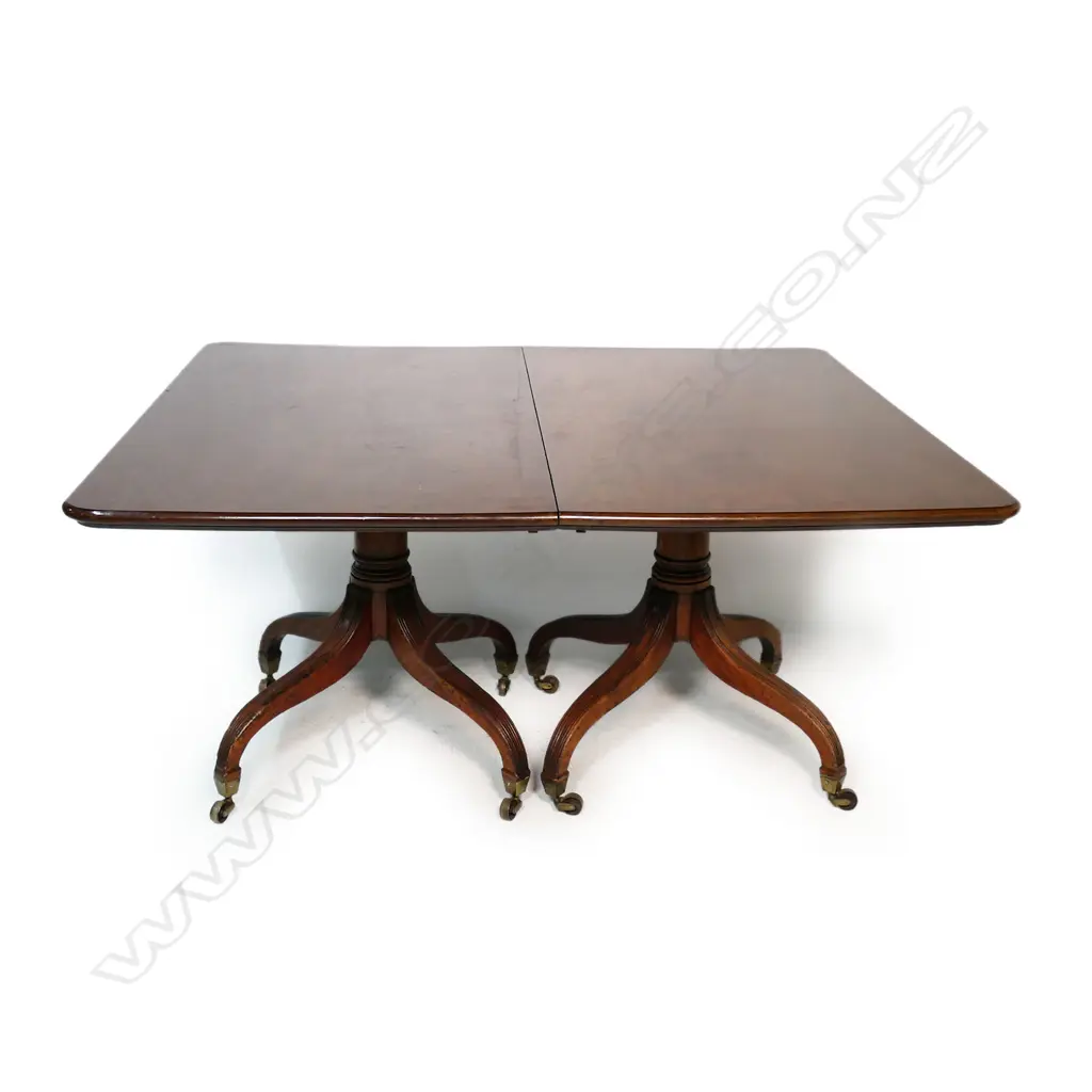 A Regency mahogany double pedestal dining table - with two extension leaves, brass casters. 1500 x 1300 x 730mm (2620mm when extended). Image 1++