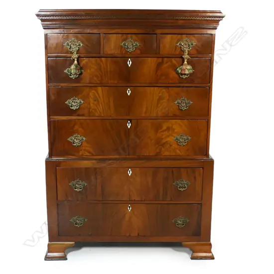 A mahogany Georgian style chest on chest - the top with three small drawers over three full width drawers, the base with two full width drawers, bone keyhole escutcheons, the pediment with restrained decoration, replacement brass handles, raised on bracket feet. 1030 x 530 x 1520mm.