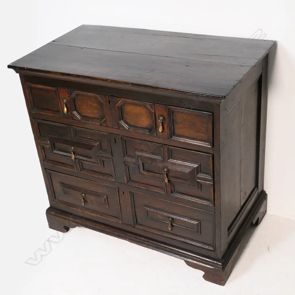 An oak William and Mary style three drawer chest - geometric panels to the drawers, hanging brass handles, raised on bracket feet. 970 x 560 x 900mm. Image 1++