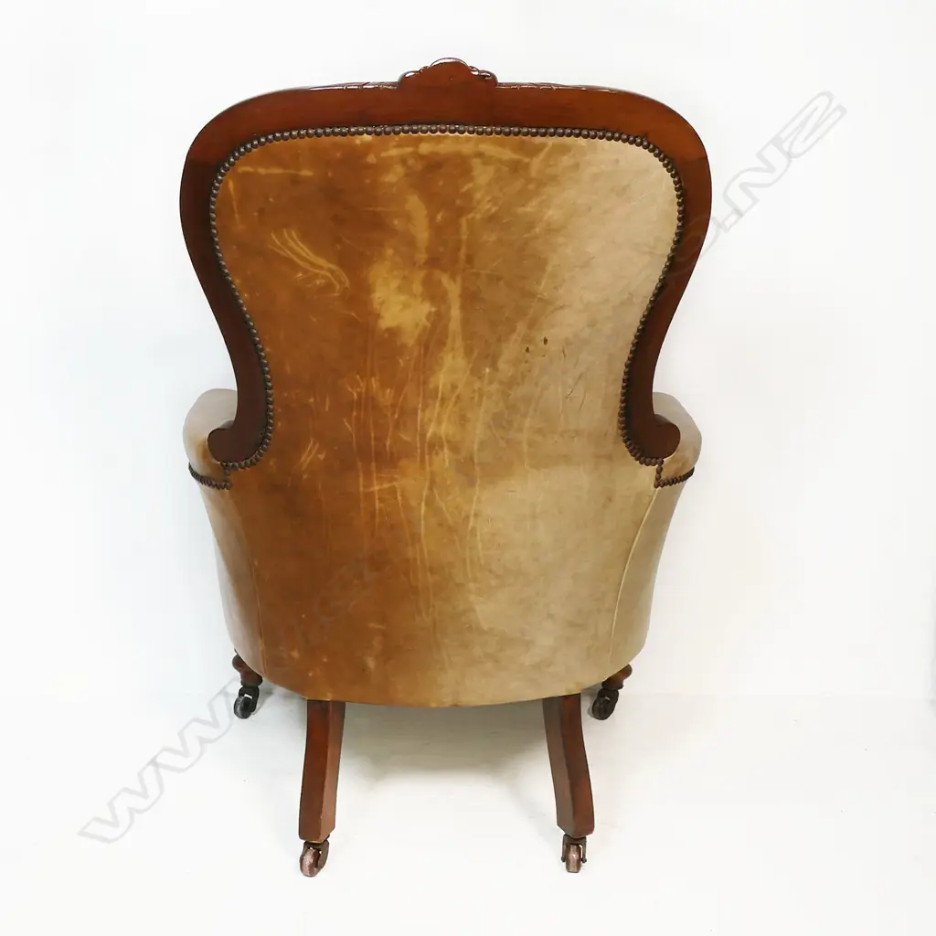 A Victorian mahogany and leather grandfather chair - carved frame, button back with upholstery nail detail. Fading to the tan leather. 700 x 530 x 1040mm. Image 1++