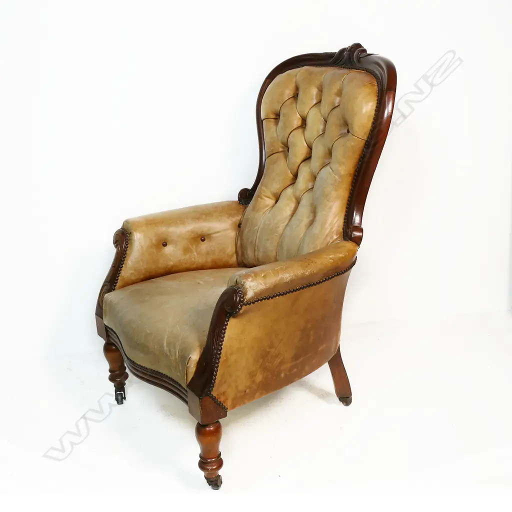 A Victorian mahogany and leather grandfather chair - carved frame, button back with upholstery nail detail. Fading to the tan leather. 700 x 530 x 1040mm. Image 1++
