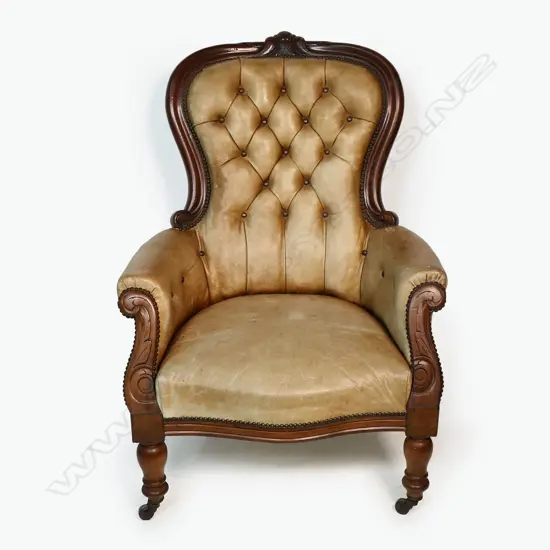 A Victorian mahogany and leather grandfather chair - carved frame, button back with upholstery nail detail. Fading to the tan leather. 700 x 530 x 1040mm.