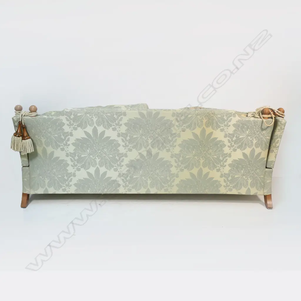 A Duresta designer three seater Knole sofa - upholstered in a self-patterned muted gold and light teal fabric, with conforming wood and cord tassels, (two faulted), with separate cushions and substantial brass casters. Provenance: Purchased from Baran de Bourdeaux Fine Antiques. This piece has been in storage for a number of years. 2300 x 1200 x 900mm. Image 1++