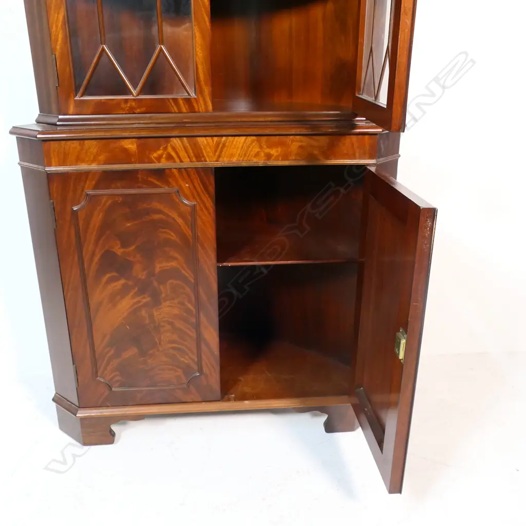 An antique style mahogany corner cabinet - the astragal glazed top with two doors, decorative pediment, over the base with two panelled doors with figured mahogany, raised on bracket feet. 900 x 400 x 1780mm. Image 1++