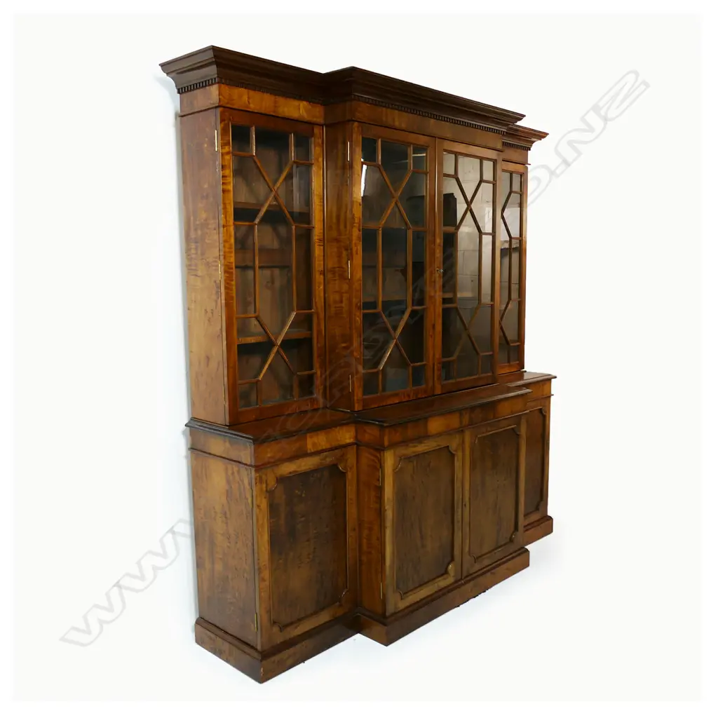 A mahogany Georgian style breakfront bookcase - dentil moulding to the pediment, four astragal glazed doors, the interior with two adjustable shelves, the base with four panelled doors, raised on plinth base. 1920 x 490 x 2000mm. Made by Don Barrett, cabinet maker and antique furniture restorer, for his family home. Image 1++