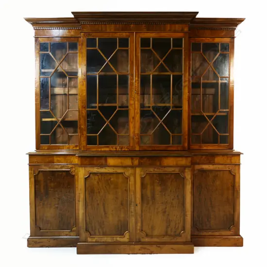 A mahogany Georgian style breakfront bookcase - dentil moulding to the pediment, four astragal glazed doors, the interior with two adjustable shelves, the base with four panelled doors, raised on plinth base. 1920 x 490 x 2000mm. Made by Don Barrett, cabinet maker and antique furniture restorer, for his family home.