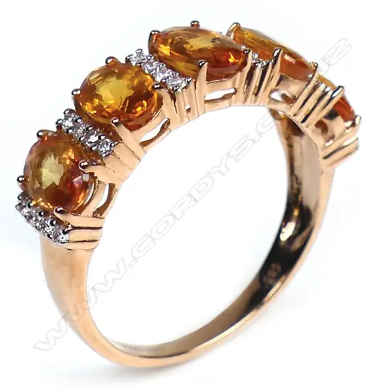 A 14ct gold orange sapphire and diamond eternity band,