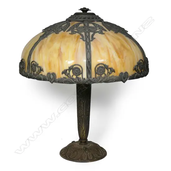 An early 20thC decorative spelter and slag glass table lamp,