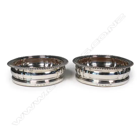 A pair of rare and impressive large silver champagne bottle coasters,