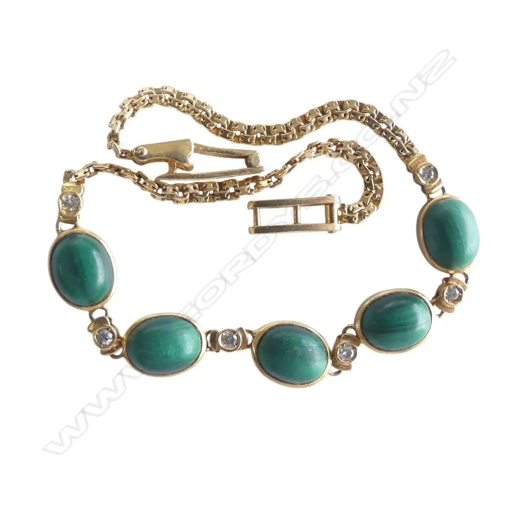 A 14ct gold malachite and diamond bracelet 7.5gms. Five oval malachite cabochons set alternatively with six small diamonds a fine articulated link chain makes up the bracelet with fold over clasp. L.200mm. Image 1++