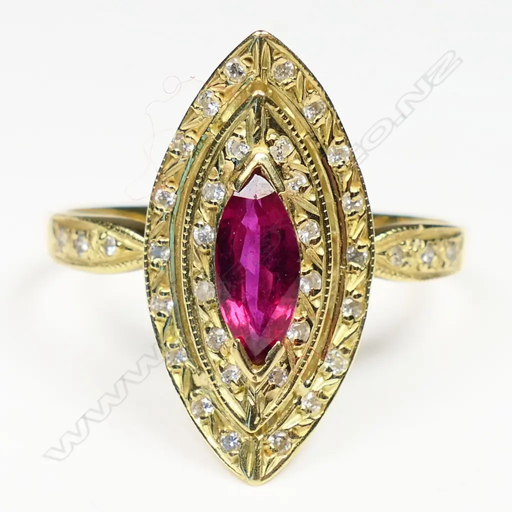 A 18ct gold ruby and diamond ring the marquis cut bright red ruby bar set at each end and surrounded by two curved marquis shaped diamond set halos three single cut diamonds to each shoulder. Image 1++