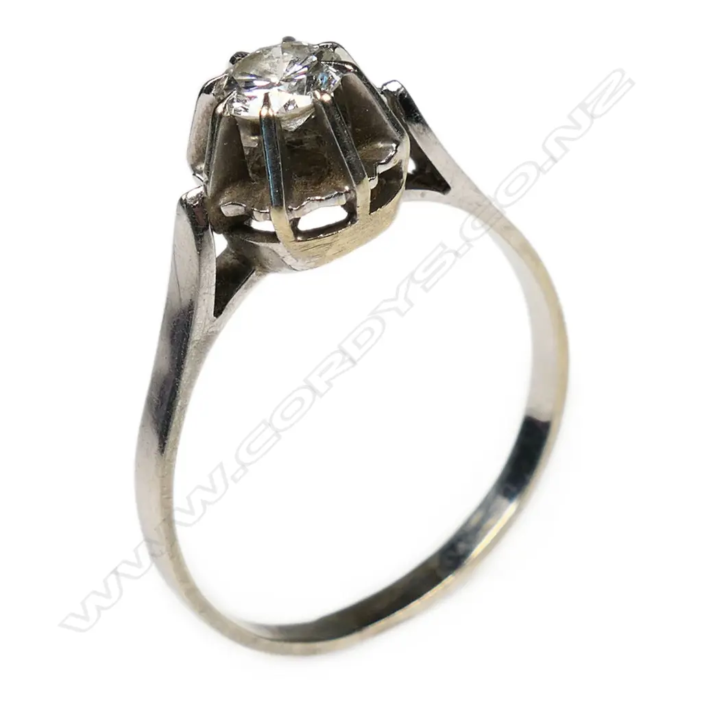 An 18ct white gold and diamond solitaire ring a round brilliant cut diamond in a high prong mount upright shoulders. Image 1++
